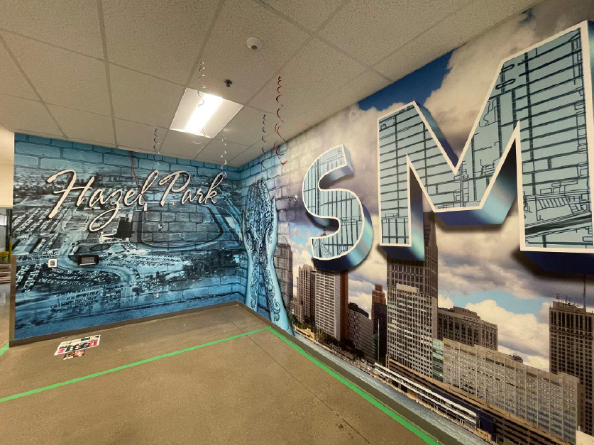 A large wall graphic featuring aerial shots of the Hazel Park community.