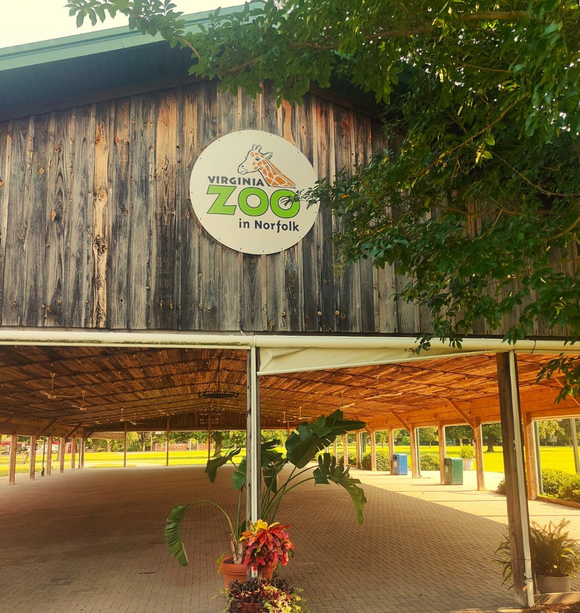 A sign that reads "Virginia Zoo in Norfolk" on the side of a large pavilion.