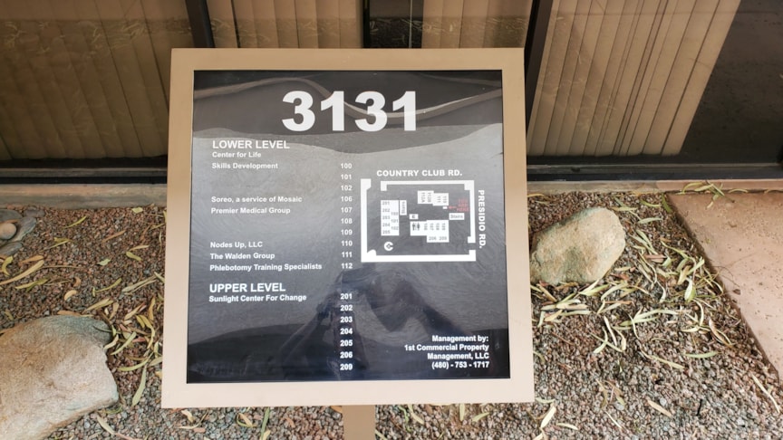 Plotted White lettering on a directory sign.