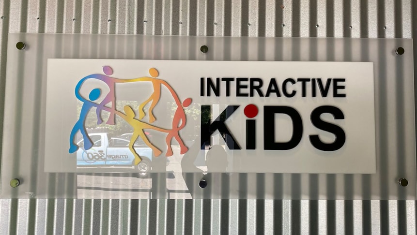 Interior acrylic signage installed on a ridged wall.