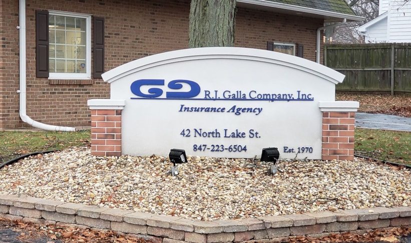 Monument sign with raised lettering on synthetic stucco with faux concrete and brick monument